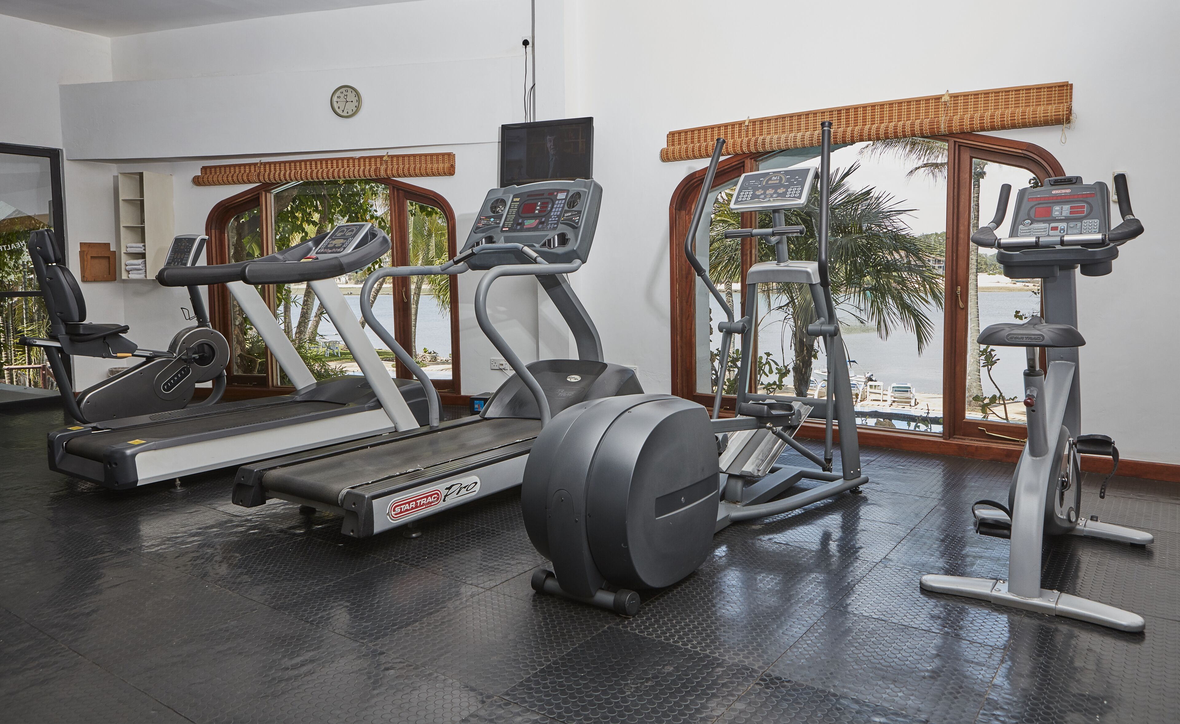 A gym with treadmills, elliptical machines, and a weight machine.