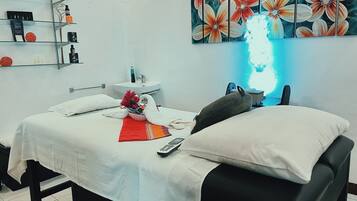 Experience comfort and simplicity in this well-appointed room, featuring a neatly made bed, a glass shelf with toiletries, and a vibrant floral artwork.