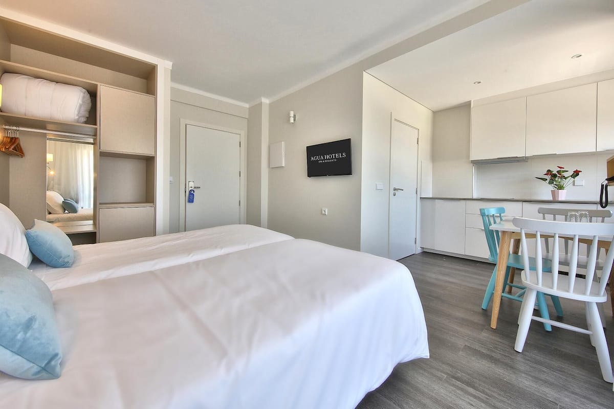 Une chambre d’hôtel avec un lit, un bureau et une kitchenette.