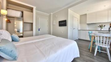 Une chambre d’hôtel avec un lit, un bureau et une kitchenette.