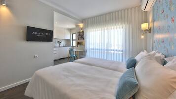 Ein Hotelzimmer mit zwei Betten, einer Küchenzeile und einem Badezimmer.