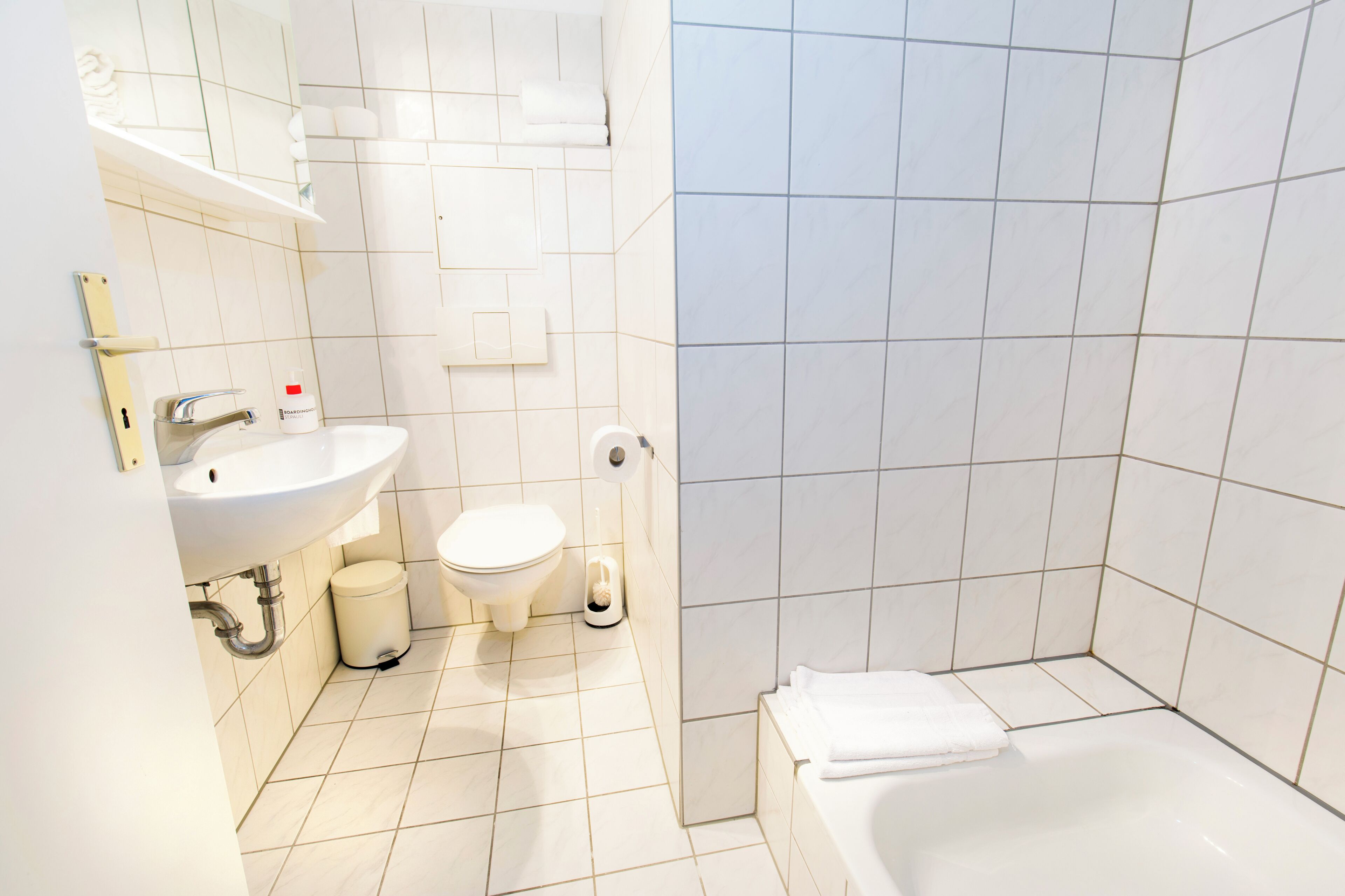 A modern bathroom with a sink, toilet, and bathtub.