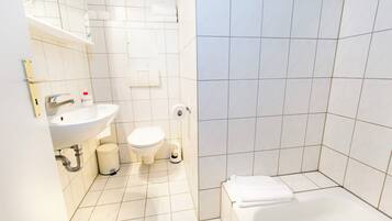A modern bathroom with a sink, toilet, and bathtub.
