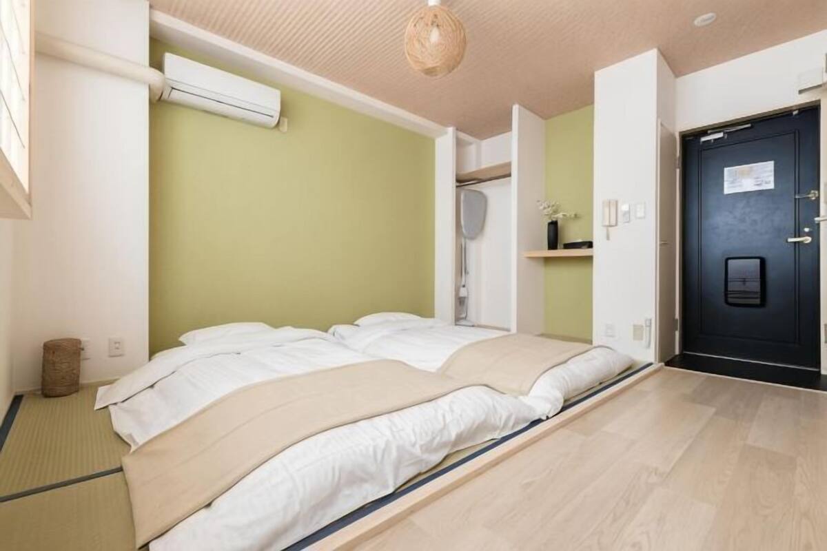 Quarto com cama, porta e ar-condicionado fixado na parede.