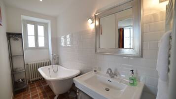 Une salle de bain avec une baignoire blanche, un lavabo et un grand miroir.