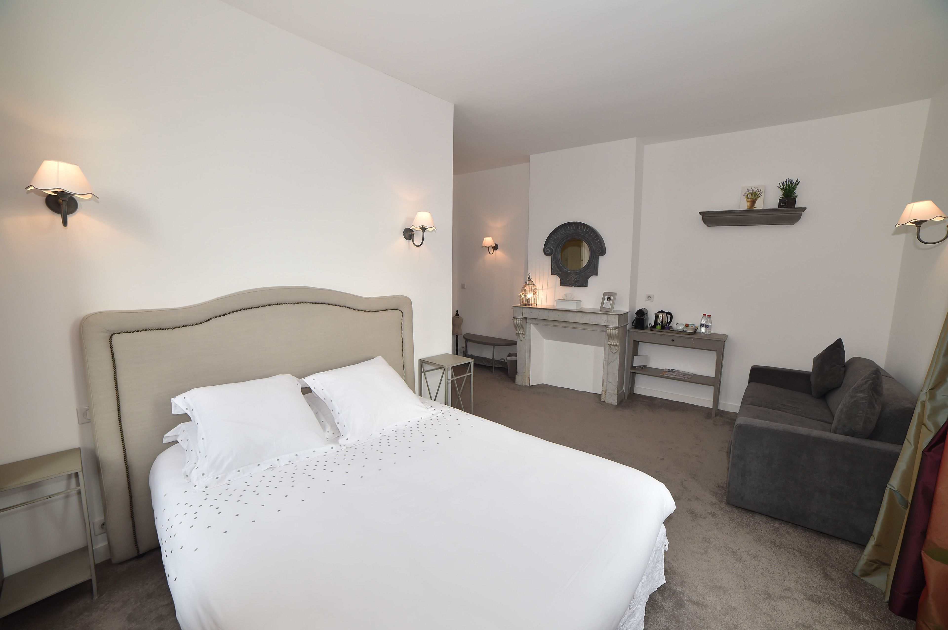 Ein Hotelzimmer mit einem großen Bett, einem Schreibtisch, einem Stuhl und einem kleinen Tisch.