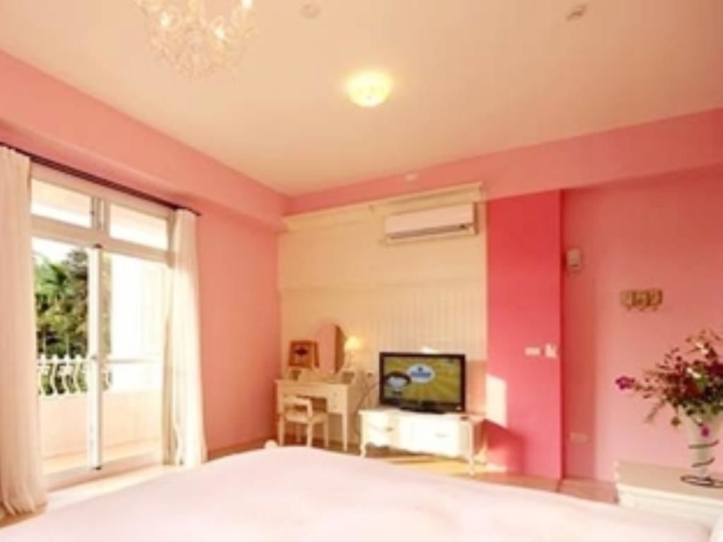 Un dormitorio con una cama grande, televisión, escritorio y una silla.