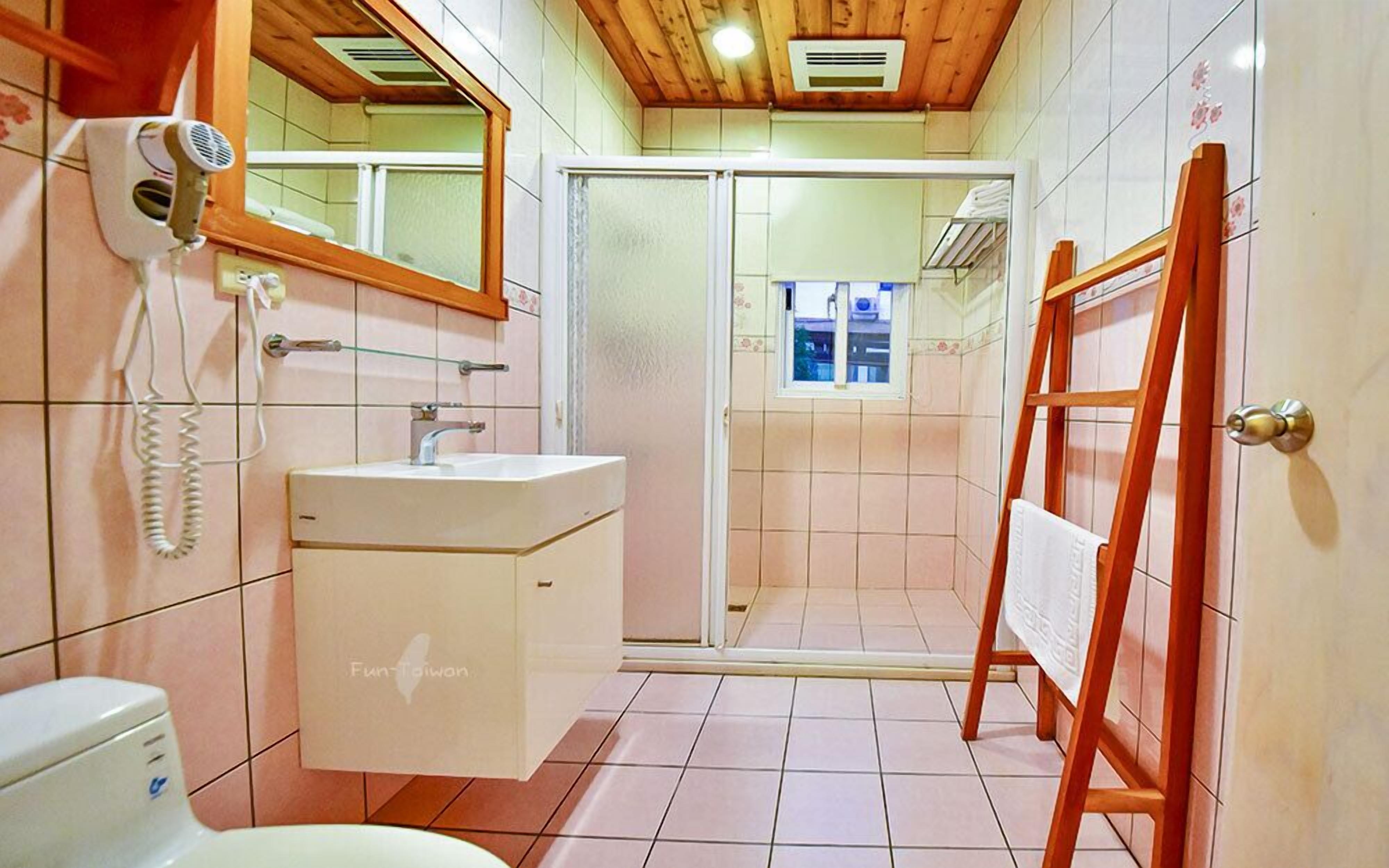 A bathroom with a sink, mirror, hairdryer, and a wooden easel.