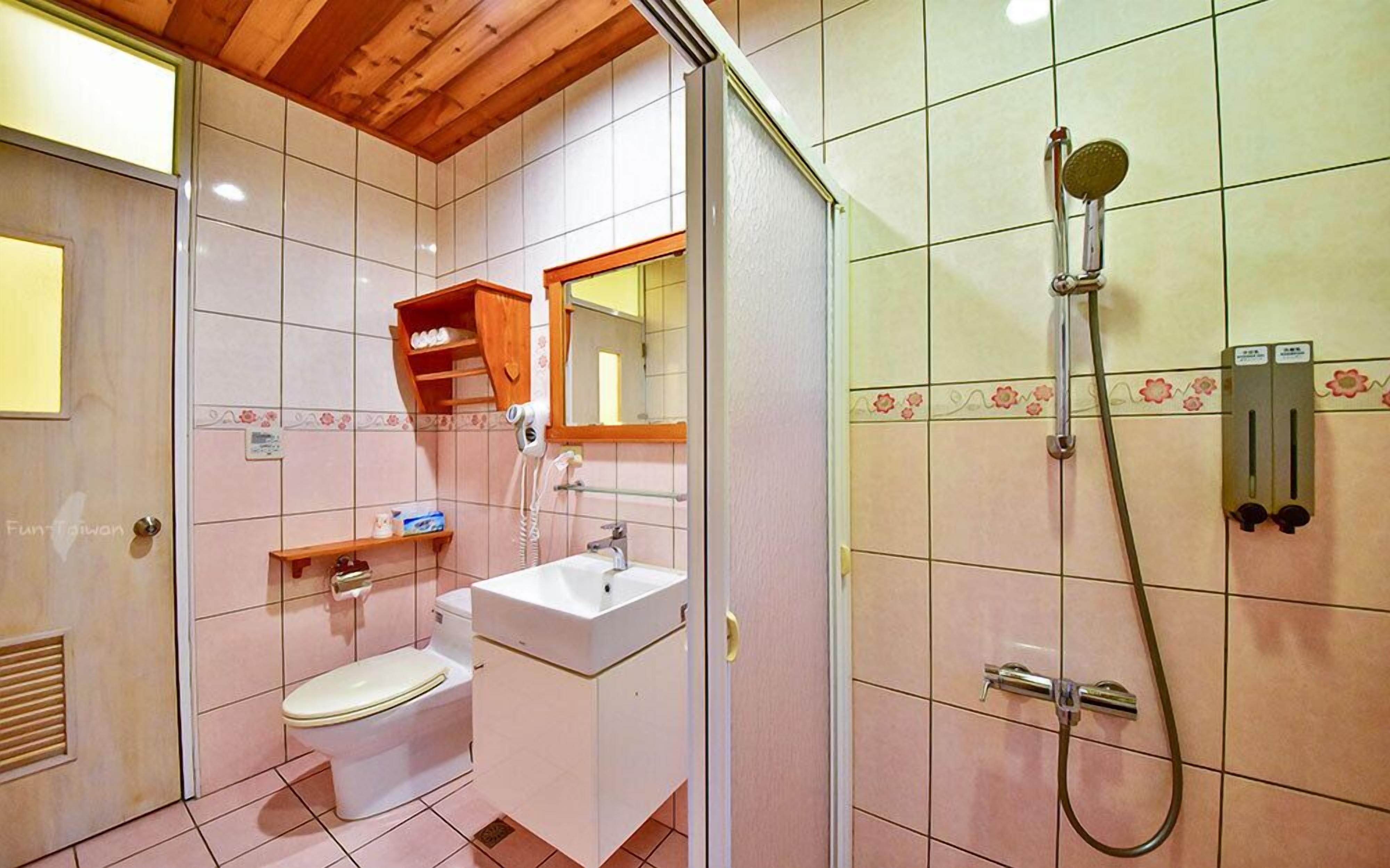 Une salle de bain avec des toilettes, un lavabo et une douche.