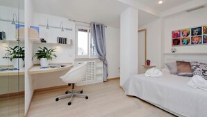 A modern bedroom with a bed, bedside table, and a desk with a chair. - Rione Trastevere apartment (Rome)