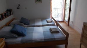 A room with two beds, a bookshelf, a desk, and a window. - Accommodation Rupine (Medulin)