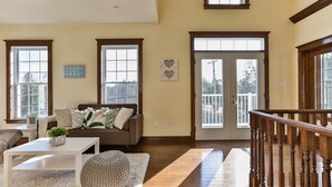 A spacious living room with a sofa, coffee table, and a staircase with wooden railings. - QuickStay Lake Simcoe Homestyle Cottage Private Beach (Georgina)