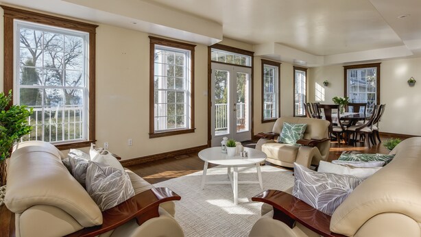 A spacious living room with large windows, a dining area, and a cozy seating arrangement. - QuickStay Lake Simcoe Homestyle Cottage Private Beach (Georgina)