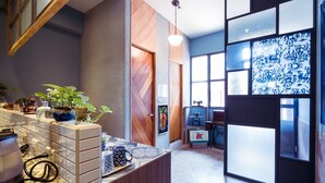 Eine moderne Küche mit Fliesenrückwand, Holzschränken und einer Arbeitsplatte mit Kaffeemaschine und Topfpflanze.