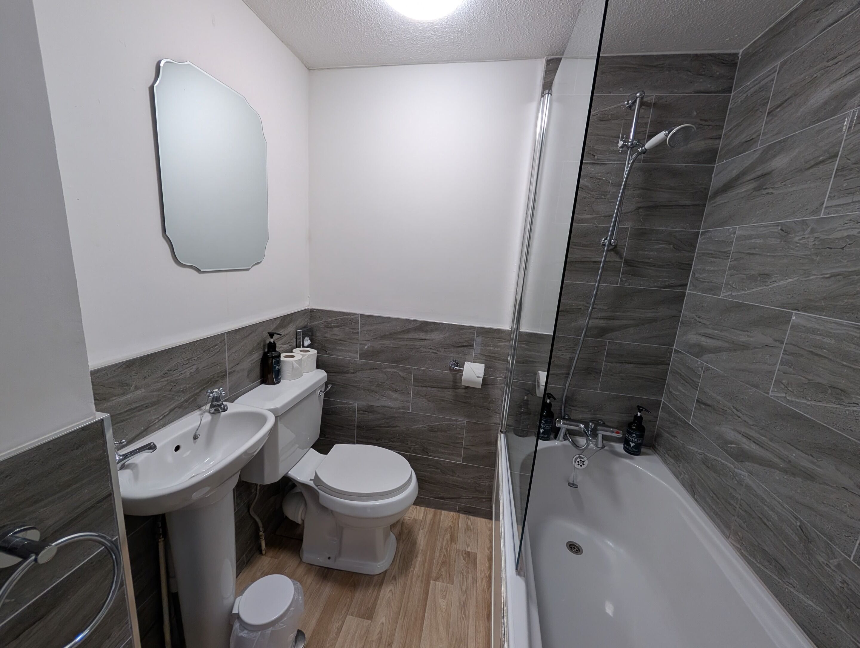 A modern bathroom with a toilet, bidet, sink, and bathtub.