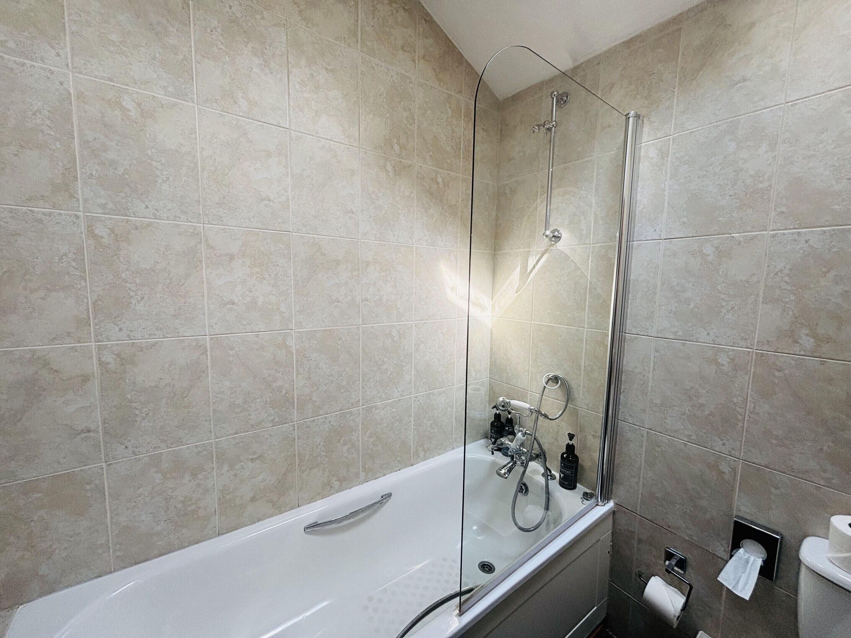 Ein modernes Badezimmer mit Badewanne, Dusche und Toilette.