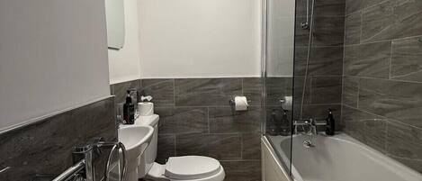 Ein modernes Badezimmer mit Toilette, Waschbecken und Badewanne.