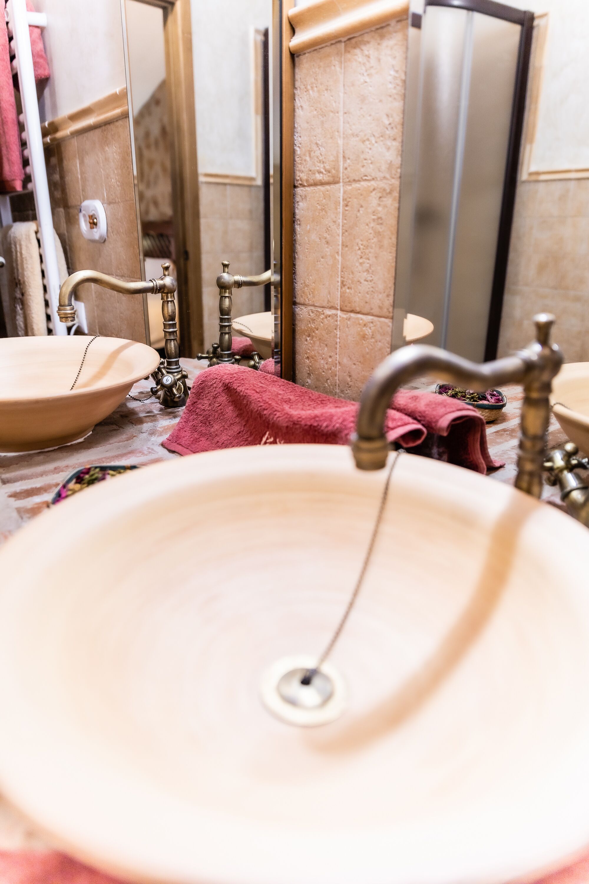 A bathroom with a beige sink, a mirror, and a towel rack.