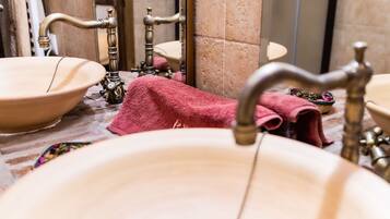 A bathroom with a beige sink, a mirror, and a towel rack.