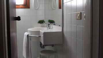 A bathroom with a white sink, a mirror, and a checkered floor.