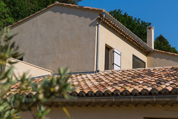 A building with a tiled roof, a chimney, and a window. - Mas de la Baume (Lafare)