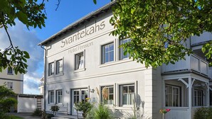 Un edificio de dos pisos con el nombre 'Svantekahs' y 'Hotel Pension' en la fachada.