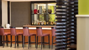 A modern bar area with a counter, several bar stools, and a variety of bottles. - StayEasy Lusaka (Lusaka)