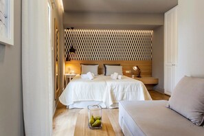 A hotel room with a bed, bedside tables, a lamp, and a seating area. - Candia Studios & Rooms (Heraklion)