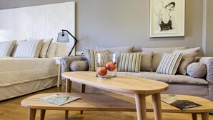A living room with a wooden coffee table, a sofa, and a potted plant.