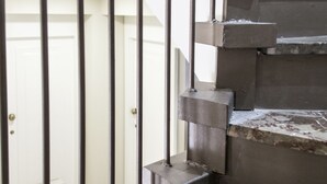 A staircase with metal railings and a white door in the background.