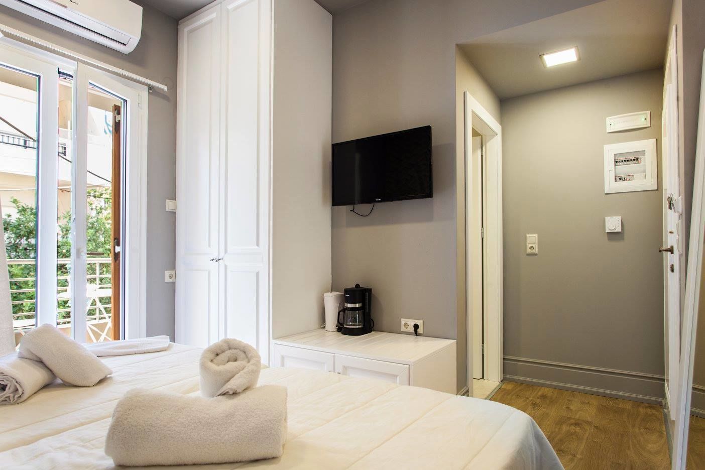 Une chambre d’hôtel avec un lit, une machine à café, une télévision et un balcon.