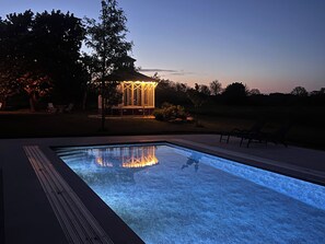 A swimming pool with a clear view of the water, surrounded by a deck area. - Torsborgs Gård (Simrishamn)