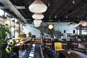 An outdoor patio with seating, potted plants, and a building with large windows in the background. at Eaton DC