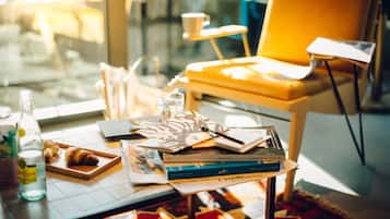 A table with books, a notebook, a pen, a glass of water, and a bottle.