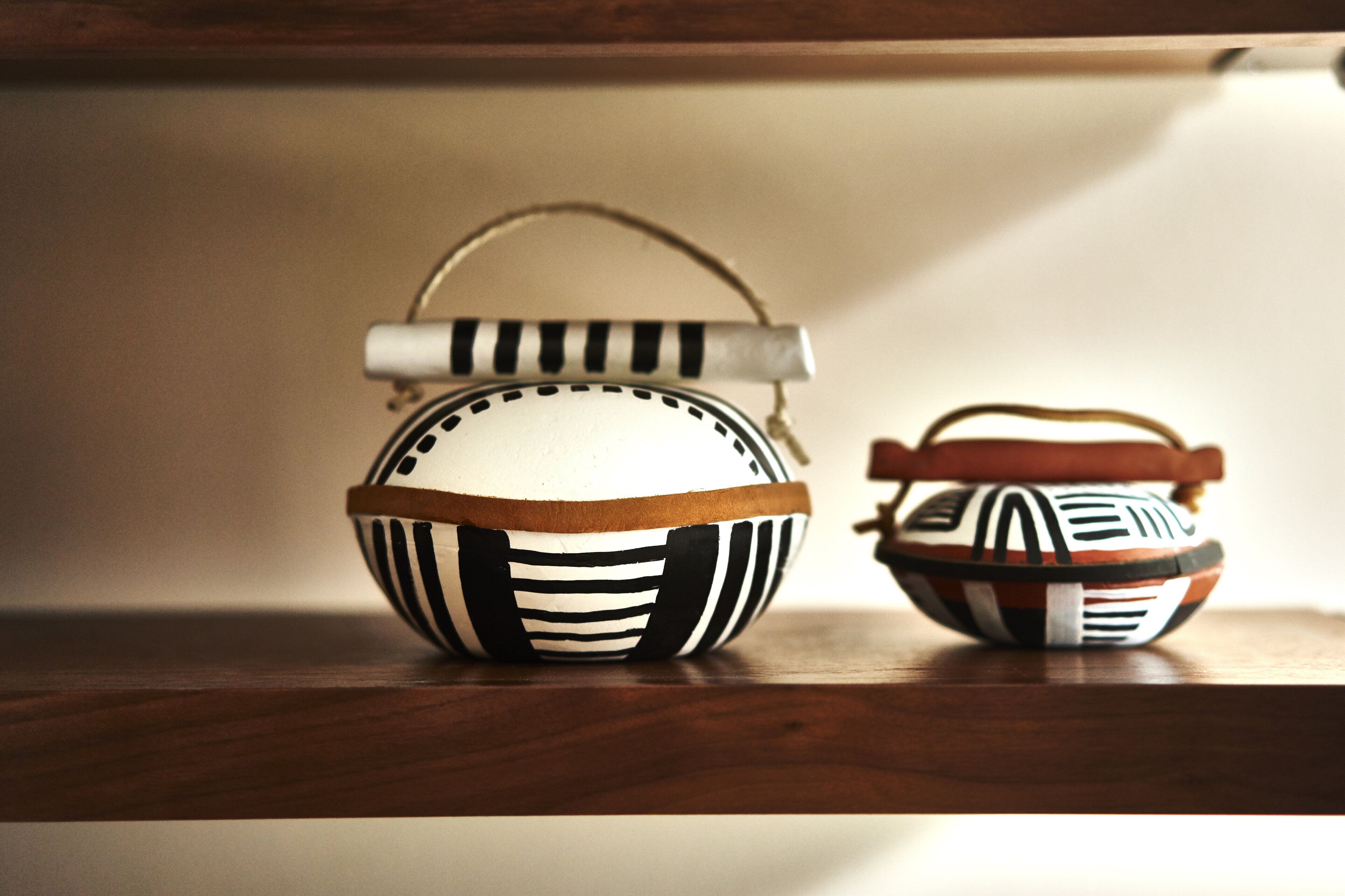 Two decorative bowls with handles on a wooden surface.
