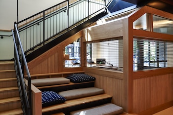 A reception desk with a wooden finish, a blue tiled wall, and a potted plant. at Eaton DC