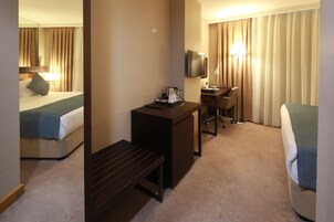 Une chambre d’hôtel équipée d’un lit, d’un bureau, d’une chaise et d’un téléviseur.