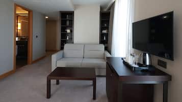 Una sala de estar moderna con un sofá, una mesa de centro, un televisor y una estantería.