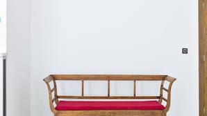 A wall with the text "ANT HOSTEL BARCELONA" and a wooden bench with a red cushion. - ANT Hostel Barcelona (Barcelona)