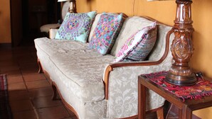 A cozy living room with a sofa, a wooden table, and a lamp. - Casa Hagan (Santa Cruz La Laguna)