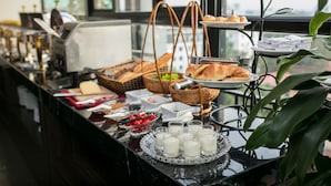 A buffet setup with various food items and beverages, including croissants, fruits, and milk. - Flora Centre Hotel & Spa (Hanoi)