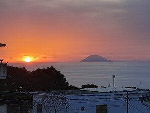 A sunset over a body of water with a distant mountain. - B&B Il Nido (Ricadi)