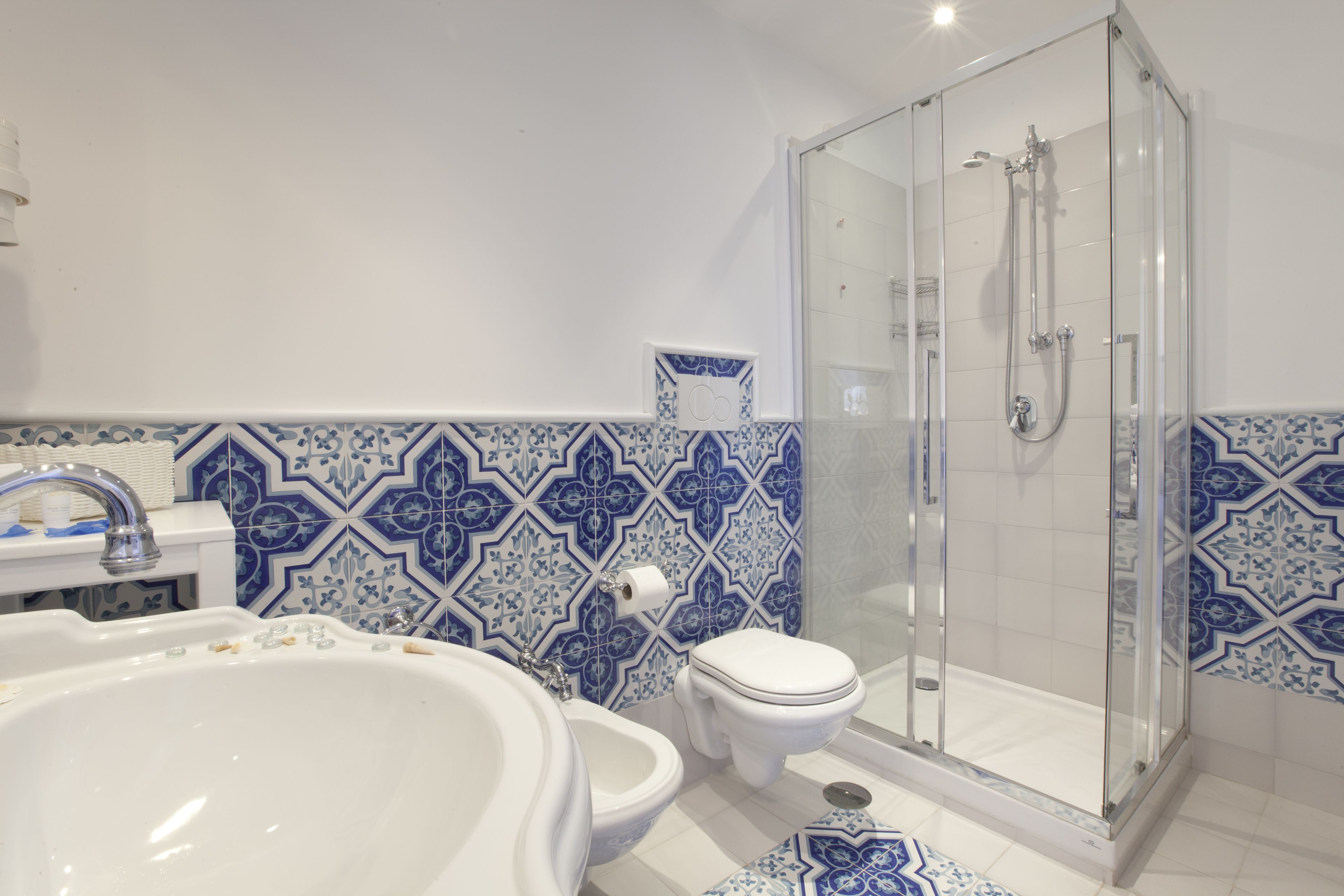 Een badkamer met een bad, toilet en douche met glazen wanden.