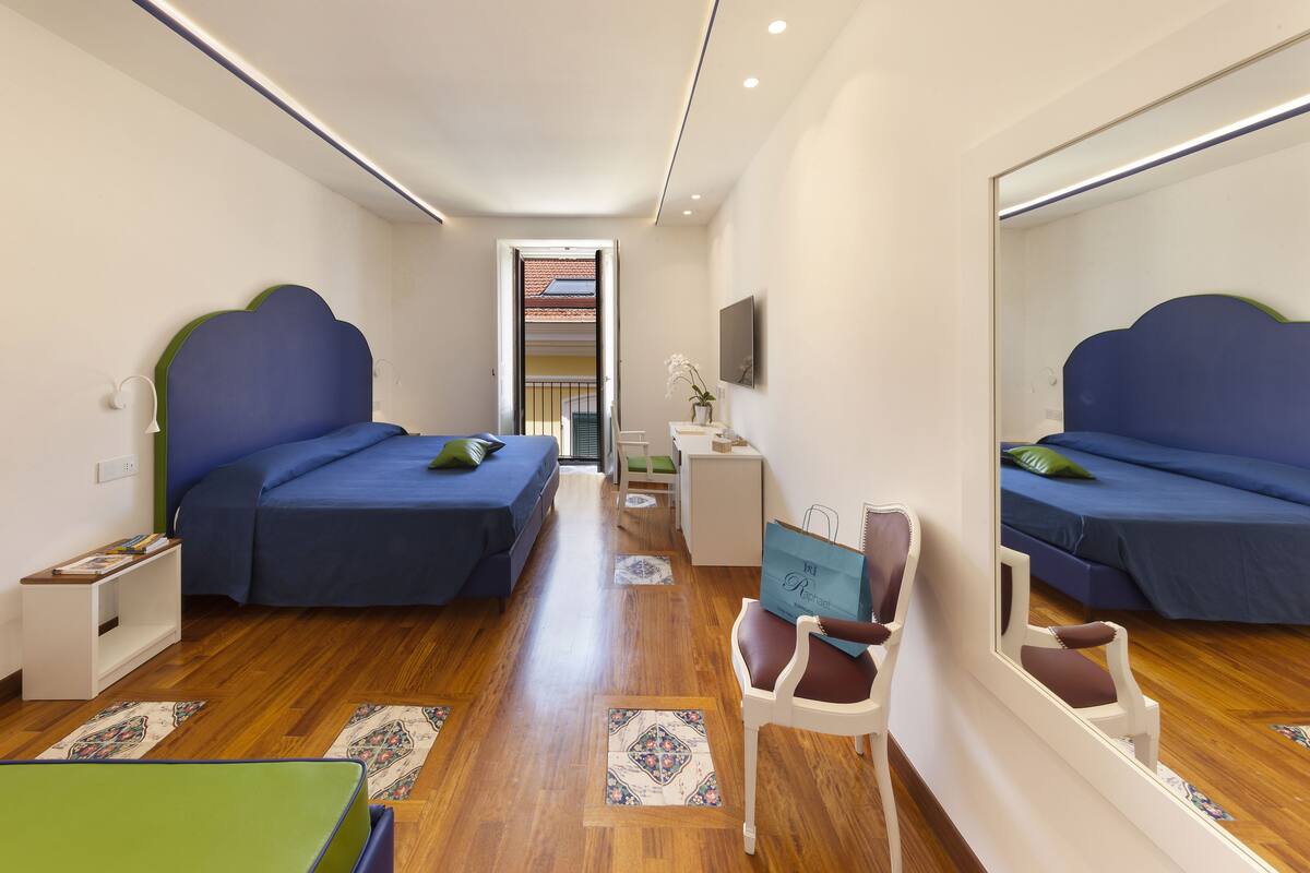 Une chambre avec deux lits, un bureau, une chaise et un miroir.