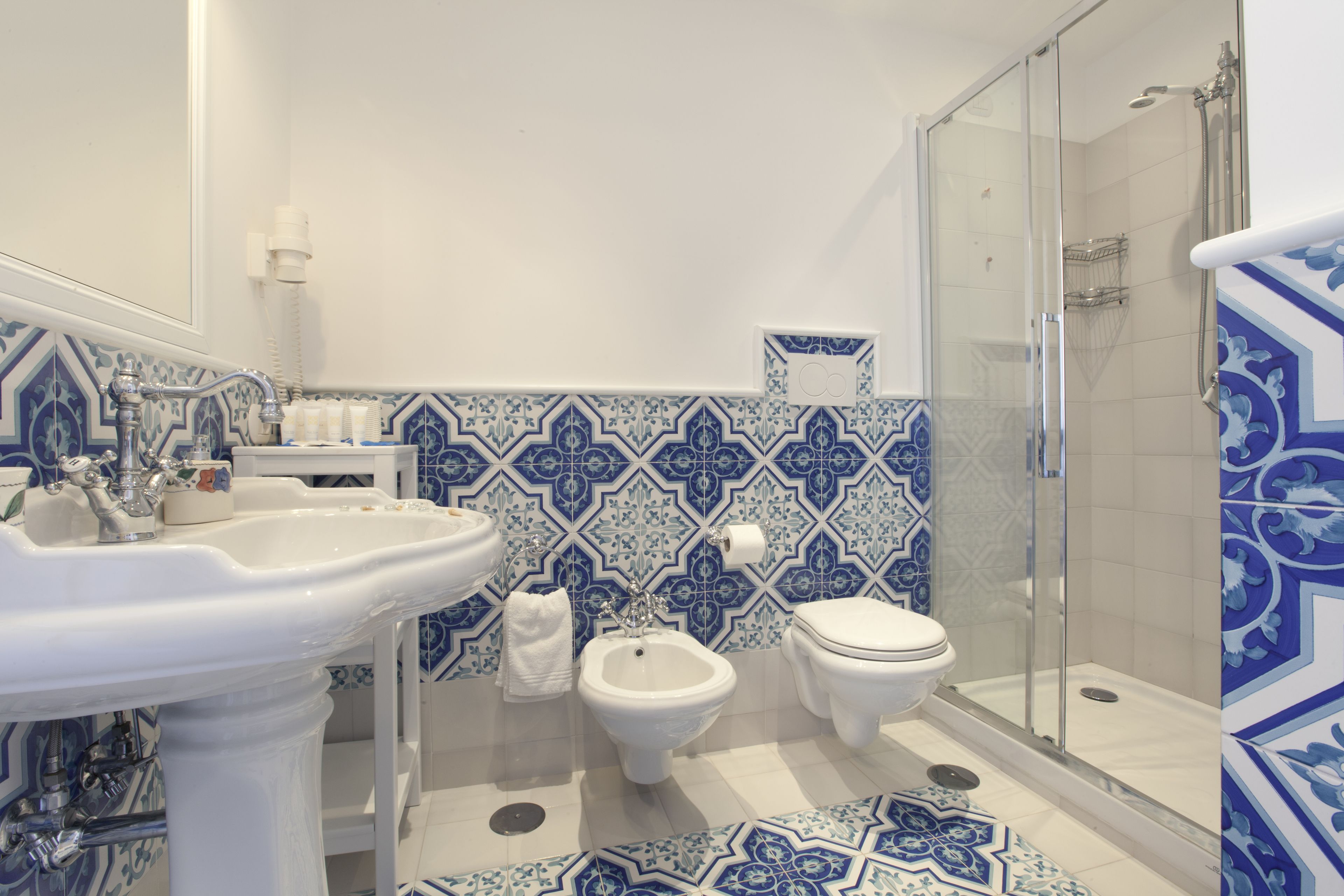 Ein Badezimmer mit einem Standwaschbecken, einem Bidet, einer Toilette und einer Duschkabine.