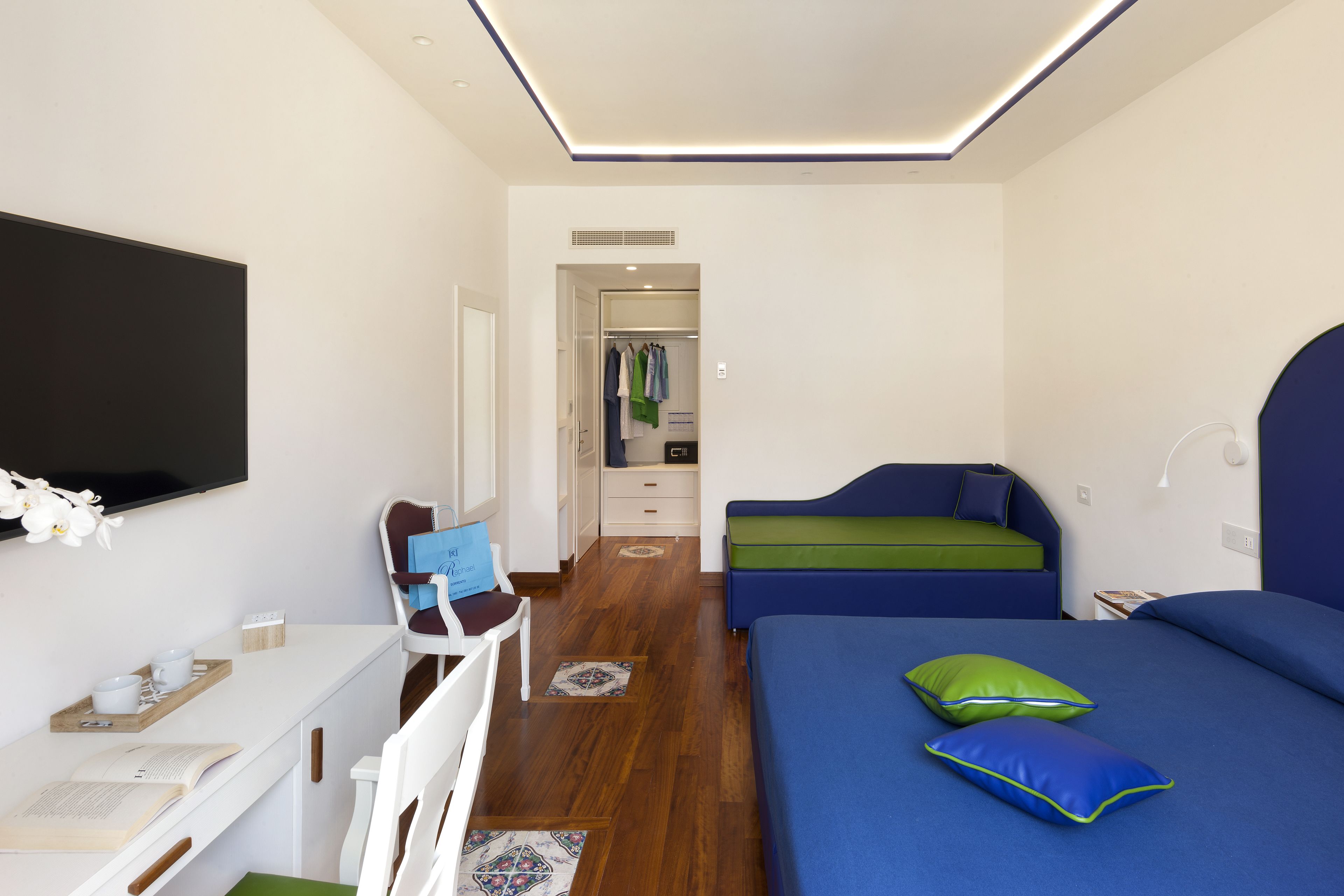 Ein modernes Schlafzimmer mit Schreibtisch, Bett und begehbarer Kleiderschrank.