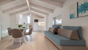Un intérieur moderne comprenant un coin repas, un canapé et une cuisine.