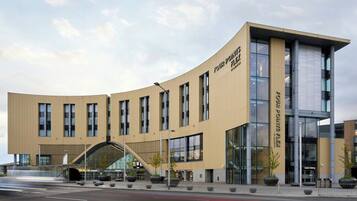 A modern building with a curved facade, large windows, and a prominent entrance.