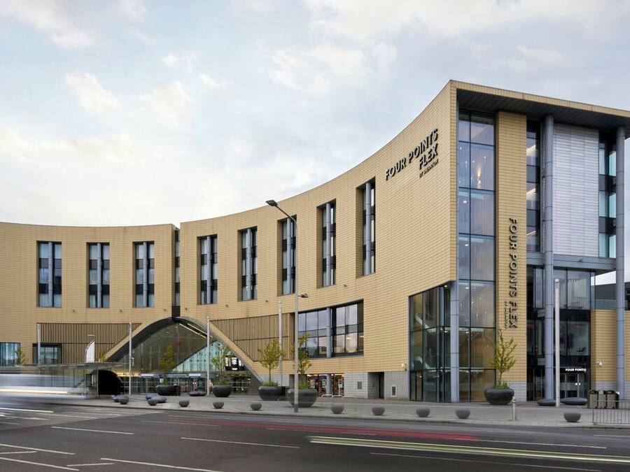 A modern building with a curved facade, large windows, and a prominent entrance.