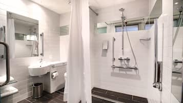A modern bathroom with a glass shower enclosure, a white sink, and a mirror.